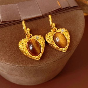 Close-up of vintage heart earrings with amber stones in a velvet gift box