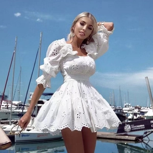 Dettagli del ricamo e pizzo su un abito bianco stile boho con maniche a sbuffo