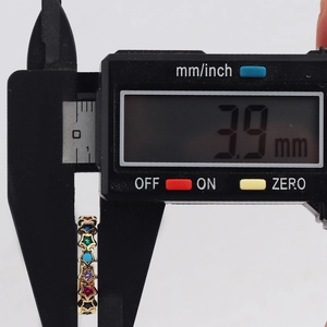 Digital caliper measuring the 3.9mm width of a colorful star-set knuckle ring band