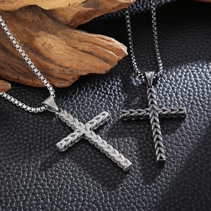 Detail of cross pendants with wheat pattern texture in silver and gunmetal finish