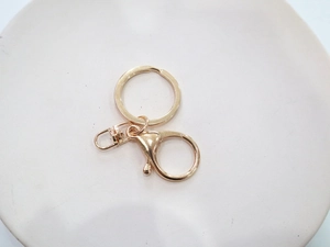 Dettaglio della chiusura a moschettone oro rosa e anello portachiavi per gioielli