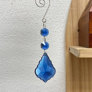 Close-up of blue faceted crystal maple leaf pendant with octagonal beads on hook