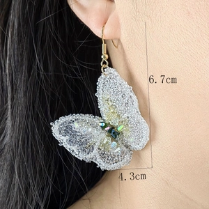 Glittering crystal woven butterfly drop earrings worn on model, size 6.7cm by 4.3cm