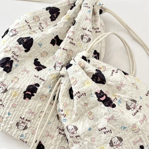 Detail of seersucker drawstring bags with cute cat and dog patterns in soft beige tones