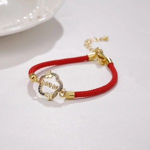 Dettaglio del bracciale rosso MAMA intrecciato con farfalla d'oro e zirconi