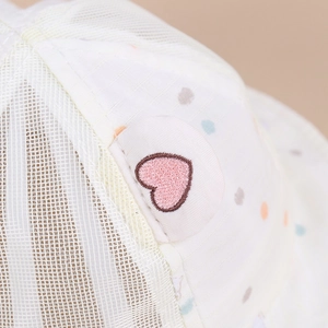 Dettaglio cappello estivo neonato con rete traspirante bianca e toppa a cuore