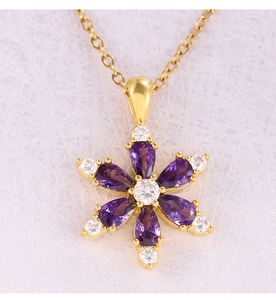 Macro shot of a floral necklace pendant with purple cubic zirconia petals and gold chain