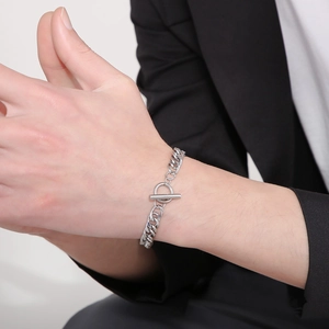 Detail of silver titanium steel curb chain bracelet with OT toggle clasp on a male model