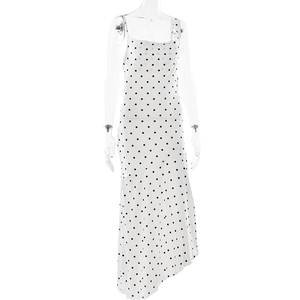 Detail of white polka dot dress featuring irregular hem and side slit design