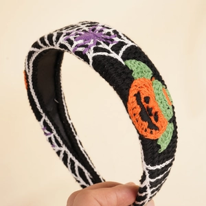 Detailed knit texture of Halloween headband with orange pumpkin and spider web