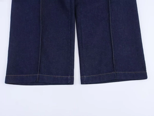 Detailansicht der dunkelblauen Jeanshose mit gelben Kontrastnähten und Wascheffekt