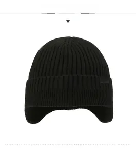 Detail of black rib-knit winter hat featuring a sport patch and ear protection design