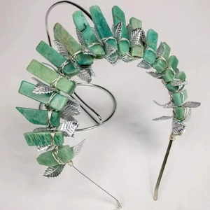 Macro detail of natural green crystal stones and silver metal leaves on the crown