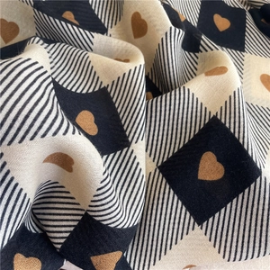 Detail shot of checkered cotton-linen scarf fabric with heart pattern and soft texture