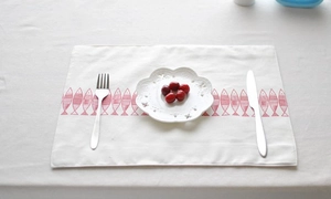 French cotton linen placemat with red fish pattern and rustic white dinnerware setup