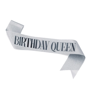 Close-up of glittery silver sash with black Birthday Queen text for party celebration