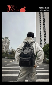 Dettaglio di un grande zaino in pelle PU nera indossato da un modello in un contesto urbano