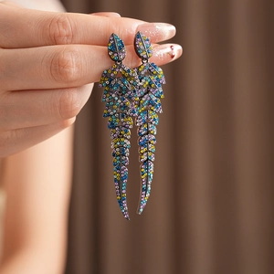 Gros plan de boucles d'oreilles vintage en forme de feuille avec strass colorés