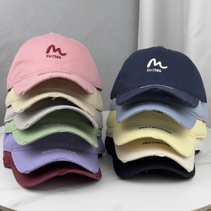 Close-up of vintage-style cotton baseball caps with distressed brims and embroidery