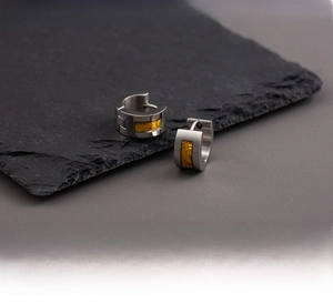 Macro shot of silver-tone stainless steel earrings with amber-colored textured inlays