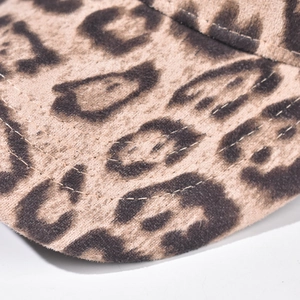Macro detail of leopard print baseball cap brim showing reinforced stitching and fabric texture