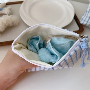 Detailed macro view of the blue and white striped fabric bag with smooth zipper closure