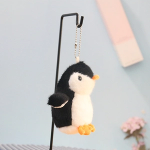 Close-up of cute black and white plush penguin keychain with metal bead chain for backpacks