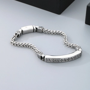 Detailed view of silver stainless steel chain bracelet with engraved Greek fret pattern