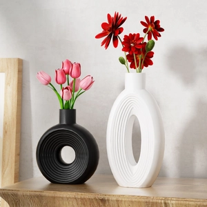 Modern minimalist hollow ceramic vases with texture featuring pink tulips in interior setting