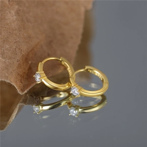 Macro shot of gold-plated S925 sterling silver hoop earrings with clear cubic zirconia