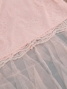 Detail of pale pink floral lace and layered tulle fabric for an elegant evening gown
