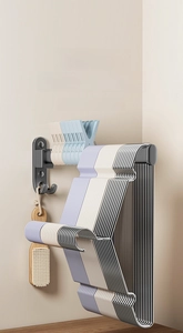 Space-saving corner wall hanger rack storing multiple plastic hangers and a cleaning brush