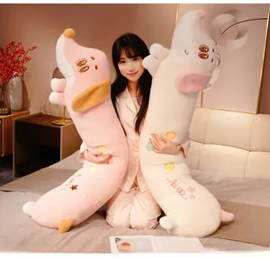 Detail of soft plush sausage dog pillows in pink and white with Happy embroidery
