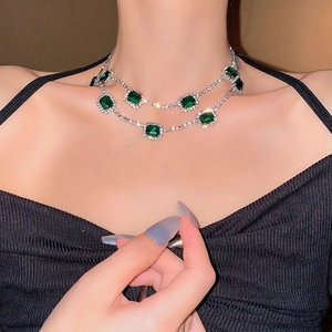 Double-layered necklace with emerald-cut green gemstones and micro-pave diamond accents