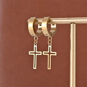 Detail of 18K gold plated hoop earrings with dangling cross charm on a display stand