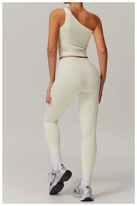 Back view of cream one-shoulder yoga set with high-waisted leggings in matte elastic fabric