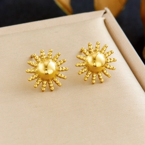 Golden sunflower stud earrings on beige padding within a premium stainless steel set