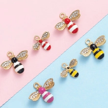 Detailed view of handmade bee charms with colorful enamel plating and sparkling rhinestones