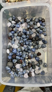 Detailed view of assorted 15mm heart-shaped natural crystals and polished quartz stones