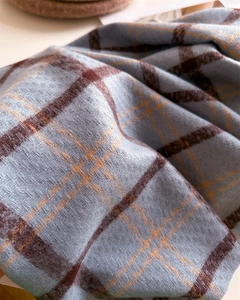 Detailed macro view of soft blue and brown checkered imitation cashmere scarf fabric texture