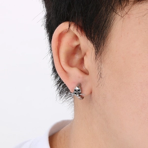 Gothic silver skull stud earring with rose detail worn by male model on ear