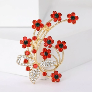Detailed view of red flower brooch with sparkling rhinestones on golden metal base