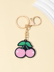 Detailed view of pink cherry keychain charm with golden metal lobster clasp and chain