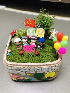 Detailed view of DIY miniature moss landscape with succulents and cartoon figures