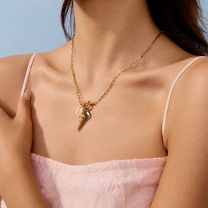 Close-up of sailor buckle necklace with 18K gold conch shell and sea charms on a model