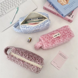 Detailed view of plush leopard print pouches with interior space for pens and stationery