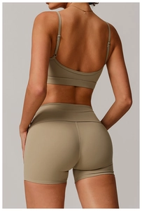 Rear view of khaki recycled yoga bra and high-waist shorts showing the V-shape back seam detail