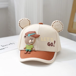 Detail showing the 3D bear decoration and LET'S GO print on the beige kids baseball cap