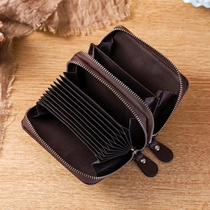 Deep brown leather RFID double zipper wallet with accordion slots on wooden surface