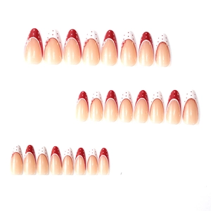 Almond press-on nails set with red bows, white polka dots, and French tips on white background